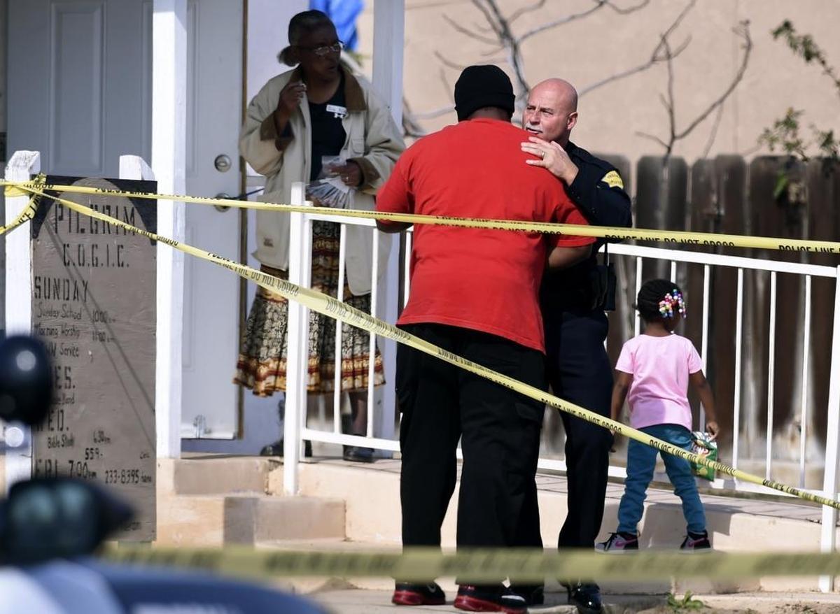 Fresno Police Chief Jerry Dyer hugs and speaks to Caleb Martin, a congregation member of Pilgrim Church of God in Christ, before addressing the media following the drive-by shooting of Zurich Chatman outside the church Saturday morning, Feb. 10, 2018 in Fresno.