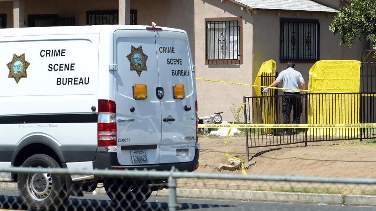 
A police investigator enters the backyard of a home Aug. 22, 2013, on McKenzie Avenue in central Fresno where the body of Oscar Seja was found in the crawl space under the house. 
