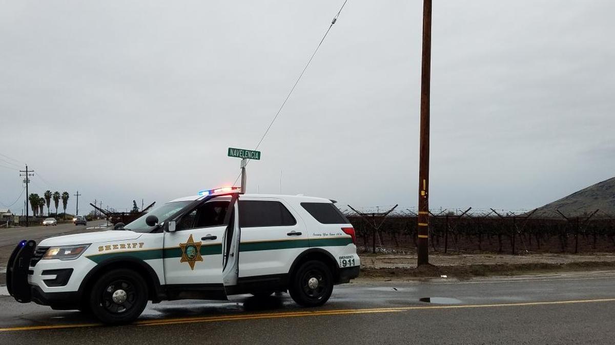 A Fresno County sheriff’s deputy blocks traffic on Navalencia Avenue near Reedley where a man’s body was found in a vineyard Saturday, Jan. 7, 2017.