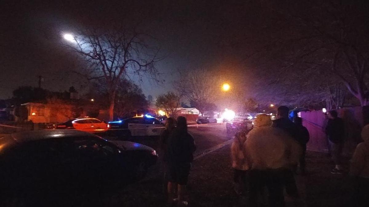 A crowd gathers Saturday, Dec. 23, 2017, during a police standoff in central Fresno. A man barricaded himself inside the home after a high-speed chase in central Fresno.