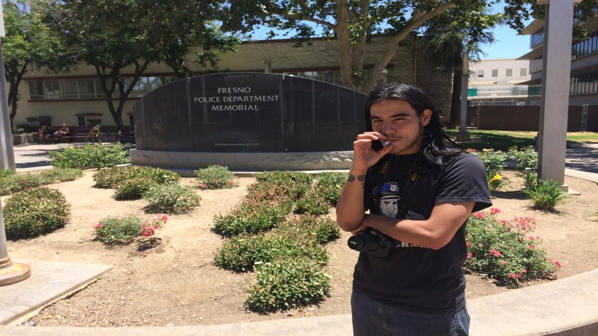 
Brian David Sumner in front of the Fresno Police Department memorial he vandalized. 

