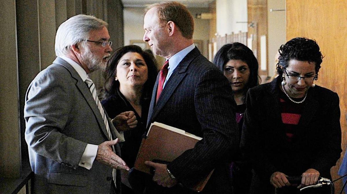 Attorney Marshall Hodgkins, left, talks to Kyle Scarber, as Gail Scarber stands in between them outside court in 2013 . Kyle and Gail Scarber and Gail’s daughter Crystal Reynoso, second from right, are on trial for allegedly helping Spencer Scarber cross into Mexico.