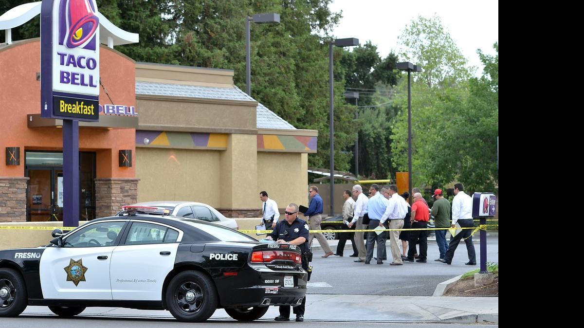 
Detectives and officials look over the scene of an officer-involved shooting at the Taco Bell parking lot on West Olive Avenue and North Warren Avenues east of Highway 99 in Fresno on July 30, 2015. The suspect was shot at by an officer when he bolted from a pat-down and ran towards that officer.  He was later found to be carrying a two-foot-long machete. No one was injured and the suspect is in custody. 
