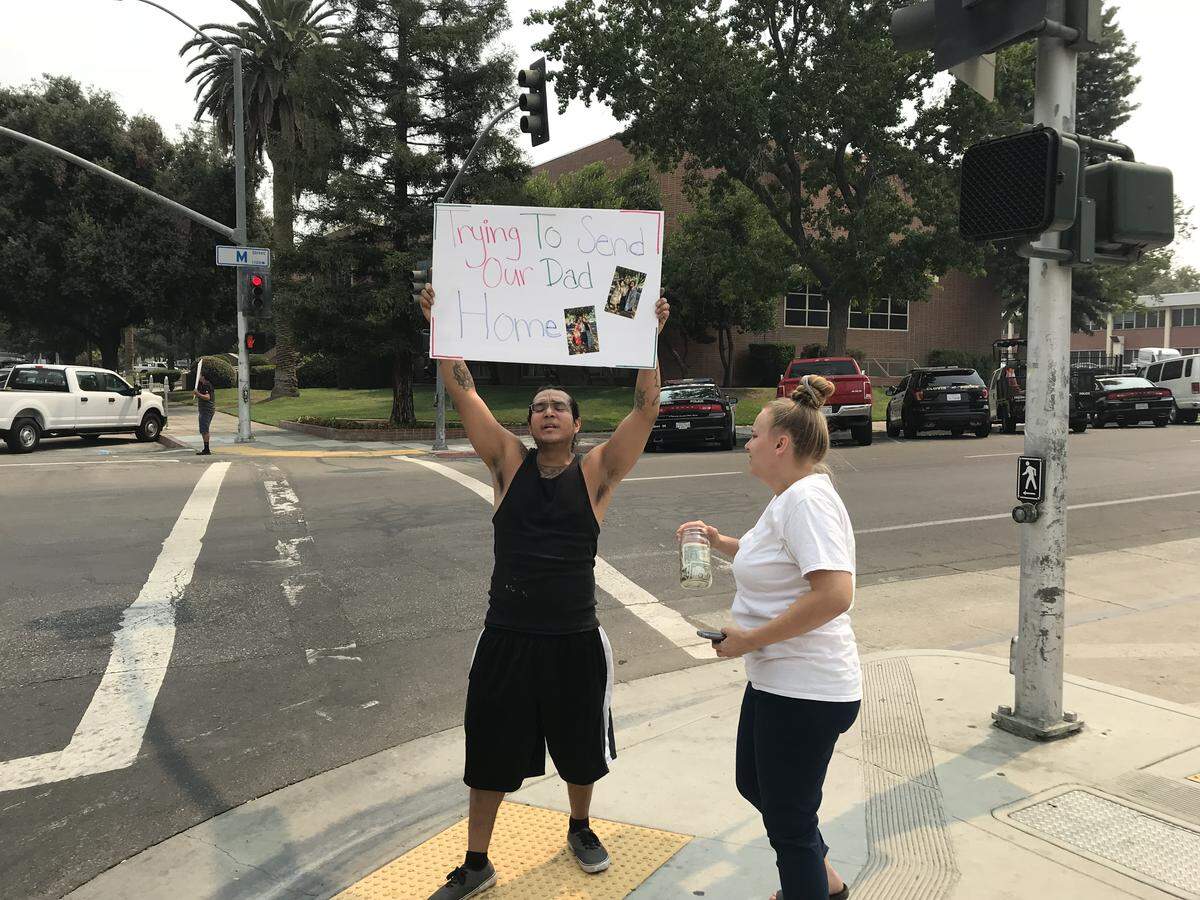 Lorin Kane Jr. holds up a sign that says: “Trying to Send our Dad home.” Kane, his wife, April Vercellini, pictured here holding a donation jar, and other relatives protested outside the Fresno County Jail on Monday, Aug. 6, 2018, after learning that Lorin Kane Sr. died unexpectedly on Aug. 1, 2018, while in custody.