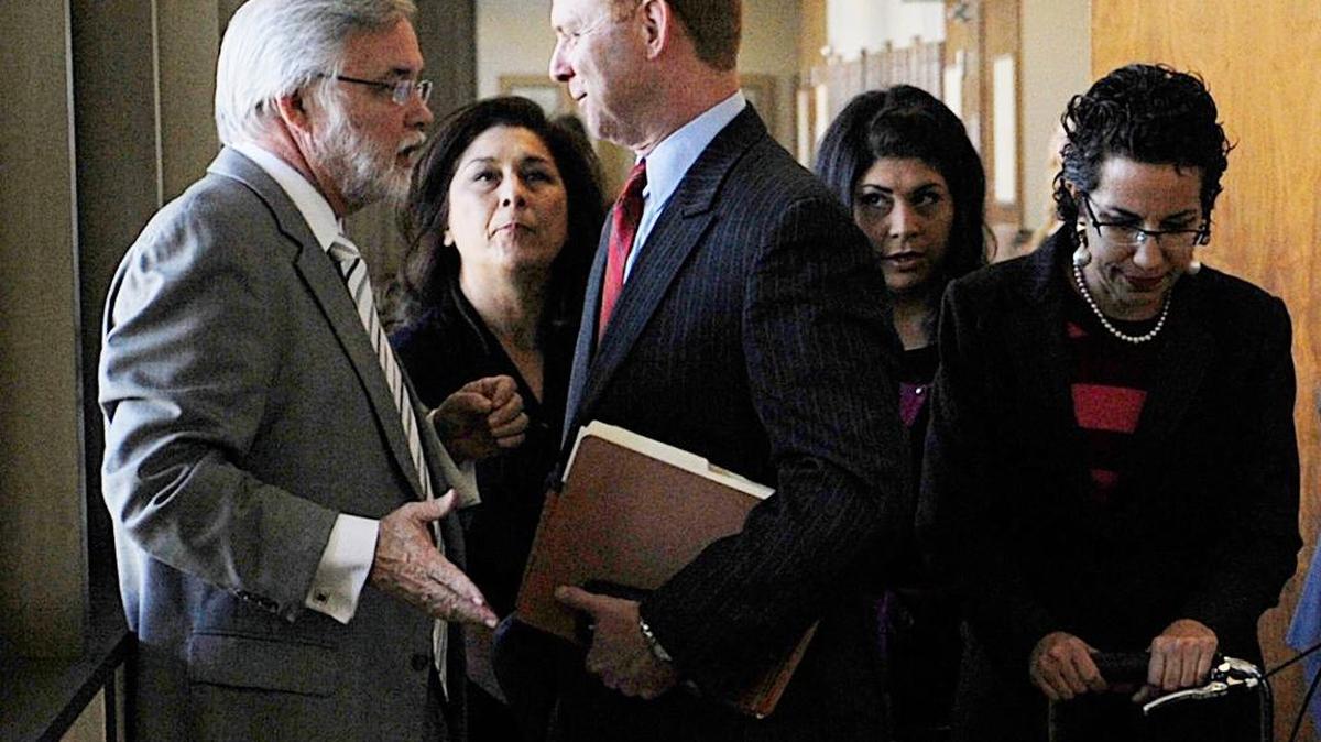 Attorney Marshall Hodgkins, left, talks to Kyle Scarber as Kyle’s wife, Gail, stands between them in a hallway outside a Fresno courtroom in 2013. In the background is Crystal Reynoso, one of the Scarbers’ daughters. The three will face charges that they helped Spencer Scarber flee from a rape case.