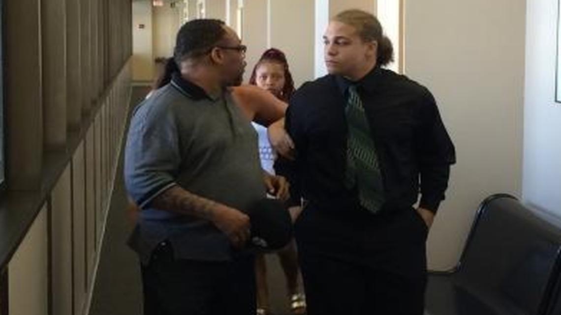 Former McLane High quarterback Herbert Stanley Johnson Jr., right, leaves a Fresno courtroom with his family Thursday after a jury convicted him of assault and robbery for an crime that happened in central Fresno in April 2013. A judge allowed Johnson to be free on bail until his sentencing next month. Next to Johnson is his father, Herbert Johnson Sr.