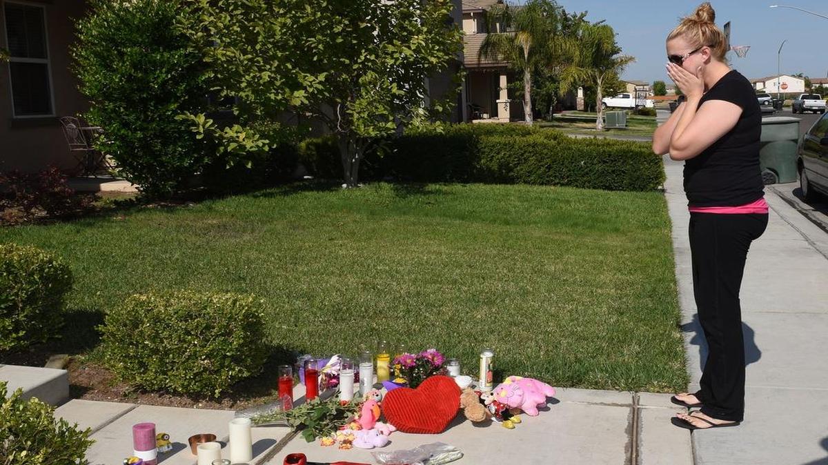 
Ashley Whatley is overcome with emotion as she leaves stuffed animals at the house on Hob Hill Court in Modesto, Calif. Monday morning (07-20-15) where five bodies were found Saturday.

