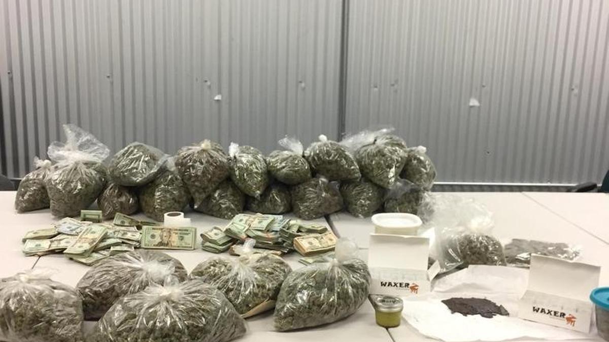 Marijuana and cash is on display after detectives with the Visalia Police Department Narcotics Unit served search warrants at two Visalia homes on Sept. 29, 2016.