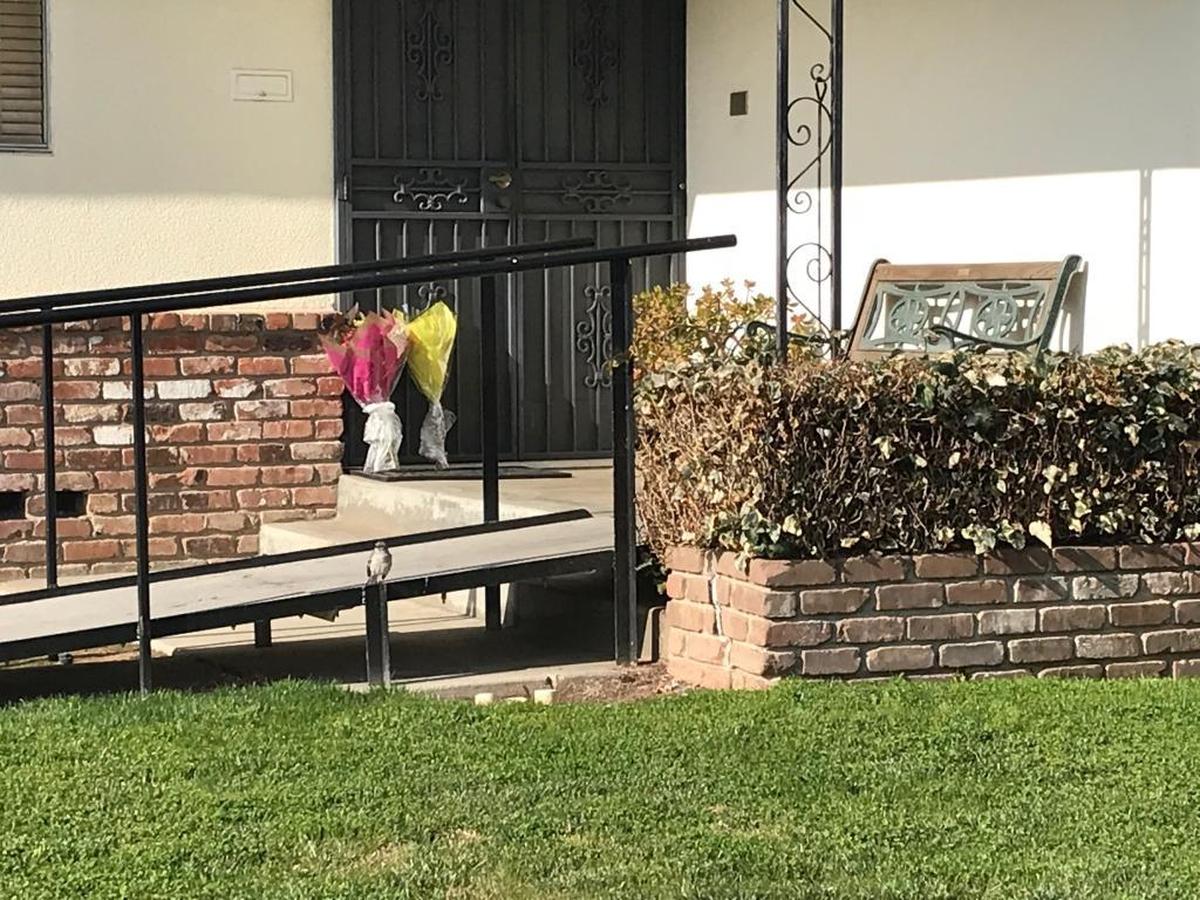 Two bouquets of flowers rest on the doorstep of the home on North Colonial Avenue in Fresno where 88-year-old Cynthia Houk and her 55-year-old daughter, Jennifer Dupras, were found dead.