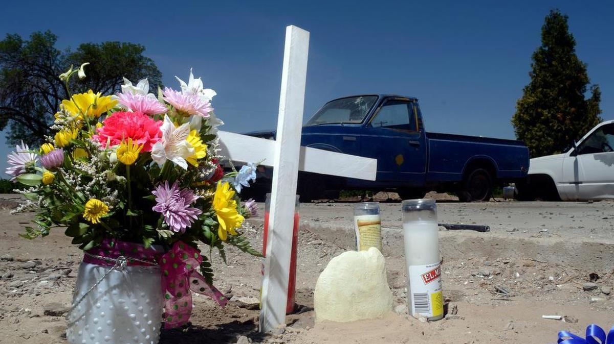 
A memorial, including a cross with an inscription to “George Jr.,” at the site where George Salwasser Jr. was fatally shot in May 2014 after he found two men stripping a stolen pickup along Howard Avenue south of the tiny town of Biola. 
