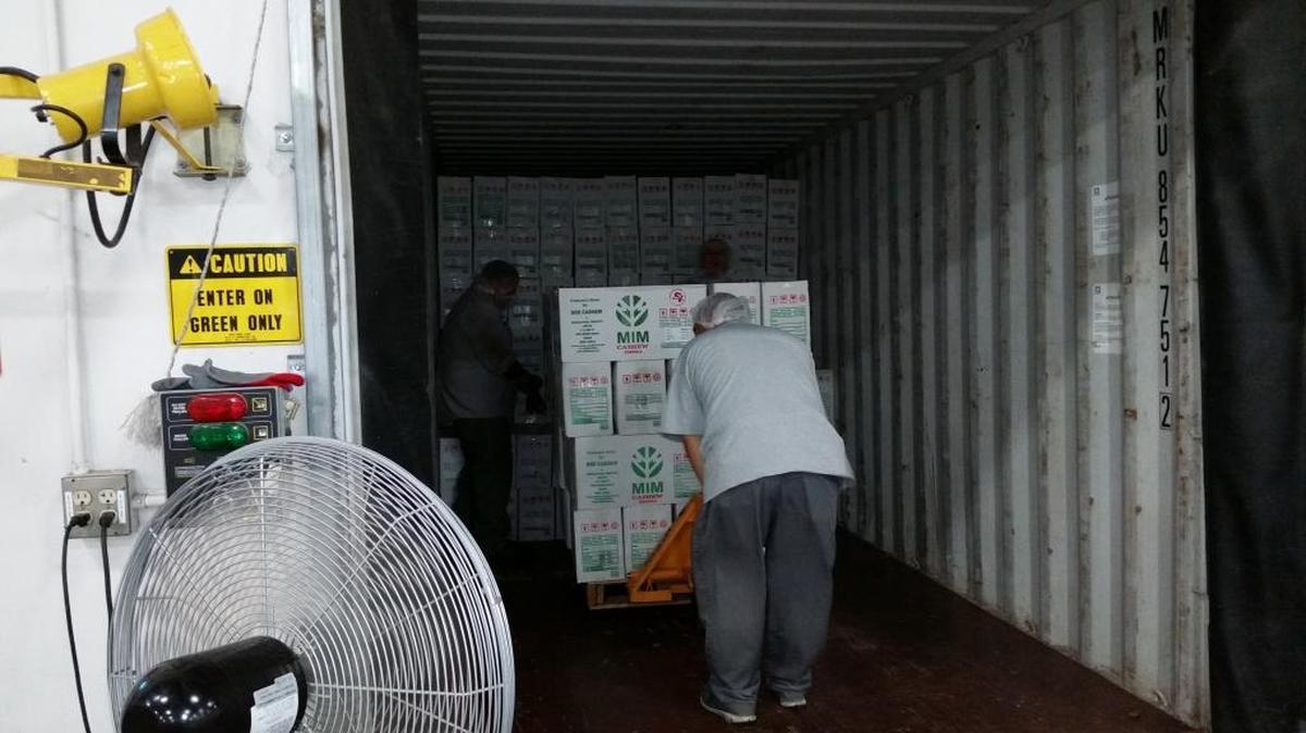 Employees of Caro Nut Co. in Fresno load boxes of processed nuts onto a truck.