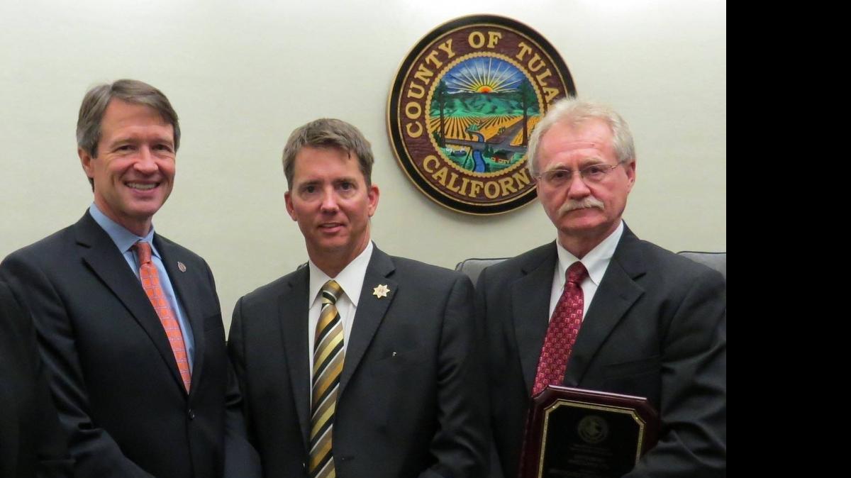 
Dwayne Johnson, right, the Tulare County district attorney investigator who uncovered a fraud scheme that scammed dozens into foreclosing their homes, receives the award as 2014’s top investigator in the U.S. Attorney’s Eastern District Office’s region. With Johnson are U.S. Attorney Benjamin B. Wagner, left, and Tulare County District Attorney Tim Ward, center.
