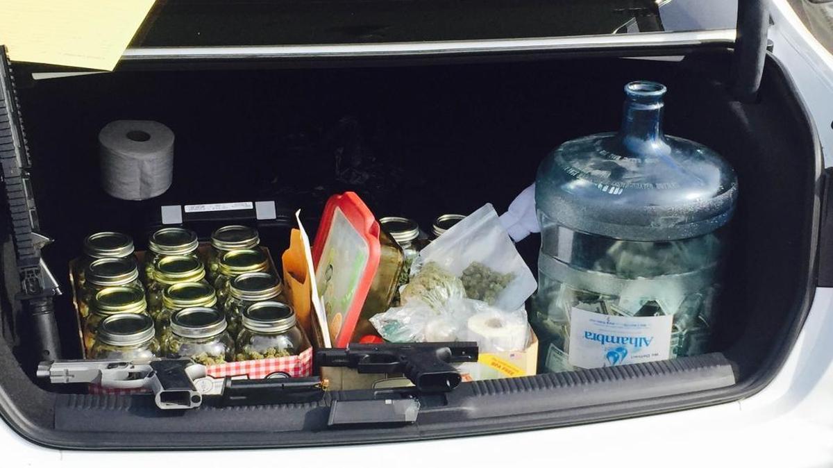 Two semi-automatic pistols, marijuana buds packaged in quart fruit jars and a five-gallon water bottle full of cash were confiscated.