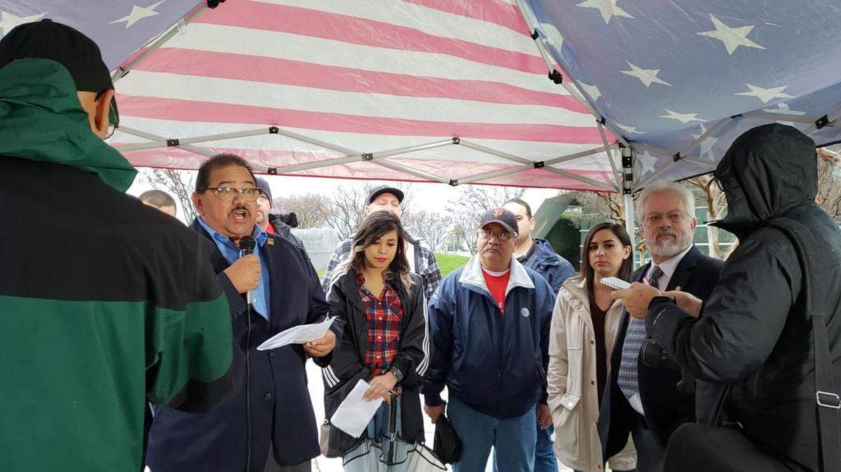 Santos Garcia, left, of the Central Labor Council, says the merging of national cell phone companies T-Mobile and Sprint is not good for consumers in the Central Valley. Garcia spoke outside Fresno City Hall before a public hearing held by the California Public Utilities Commission on Tuesday, Jan. 15, 2019.