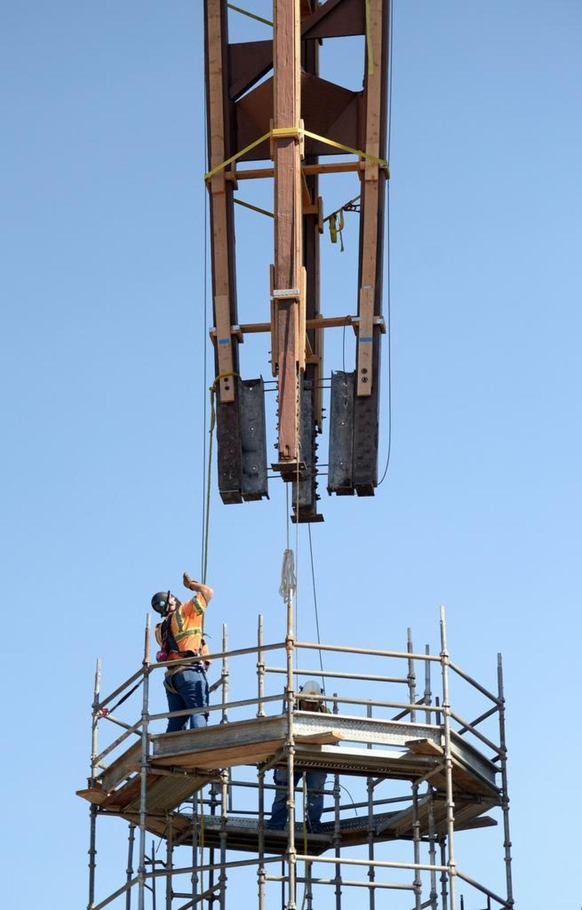 Workers lower the Fulton Mall clock tower into its new location about 30 feet to the southwest from its old spot in the middle of Fulton and Mariposa streets on Tuesday, July 18, 2017. Restoration work on the clock tower, first put in place in Fulton Mall in 1964, will begin at its new spot. Work is continuing to open the mall to vehicle traffic.
