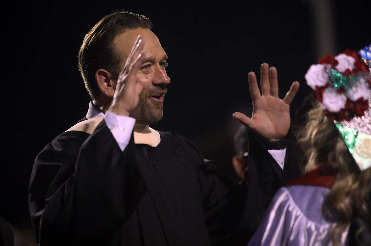 Principal Brian Wulf congratulates a graduate during the McLane High graduation at the school stadium on June 6, 2023.