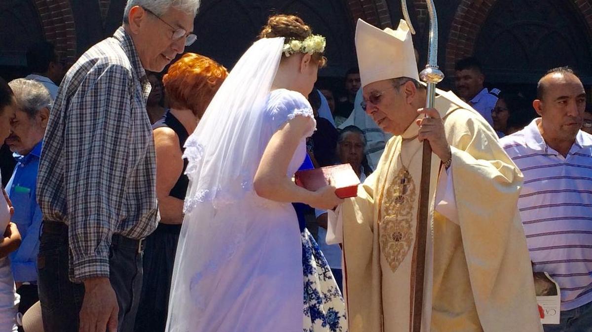 Victoria Selkirk, center in white, talks with Bishop Armando Ochoa outside St. John’s Cathedral on Sunday, May 29, after becoming the first person within the Diocese of Fresno to join a special order within the Roman Catholic Church for people who promise to live a life of chastity.