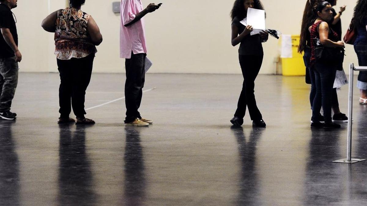 Muarshawn Washington, left of center, and Shay Maxie, right of center, wait to fill out an application during the Big Fresno Fair’s sixth annual job fair held Thursday . Big Fresno Fair Deputy Manager Lauri King said 1,000 to 1,500 applicants were expected.
