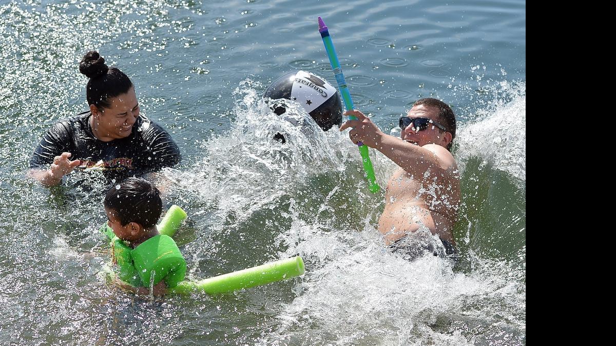 
Johana Aguirre, left, cools off in the lake with son Anahuac Aguirre, 4, center, and stepson Jonathan Aguirre, right, all of Sanger, at Avocado Lake, east of Fresno, California on May 30, 2015.
