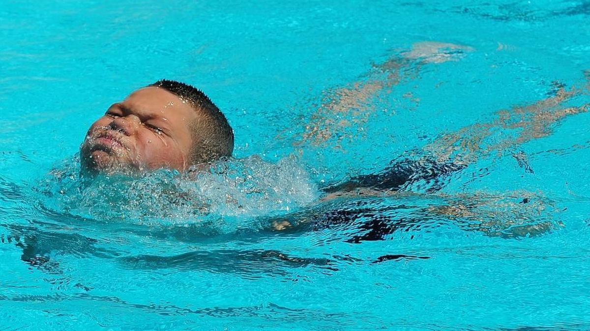 Logan Whitson, 10, swims to the side after diving at the Edison High School Aquatics Complex on Monday.