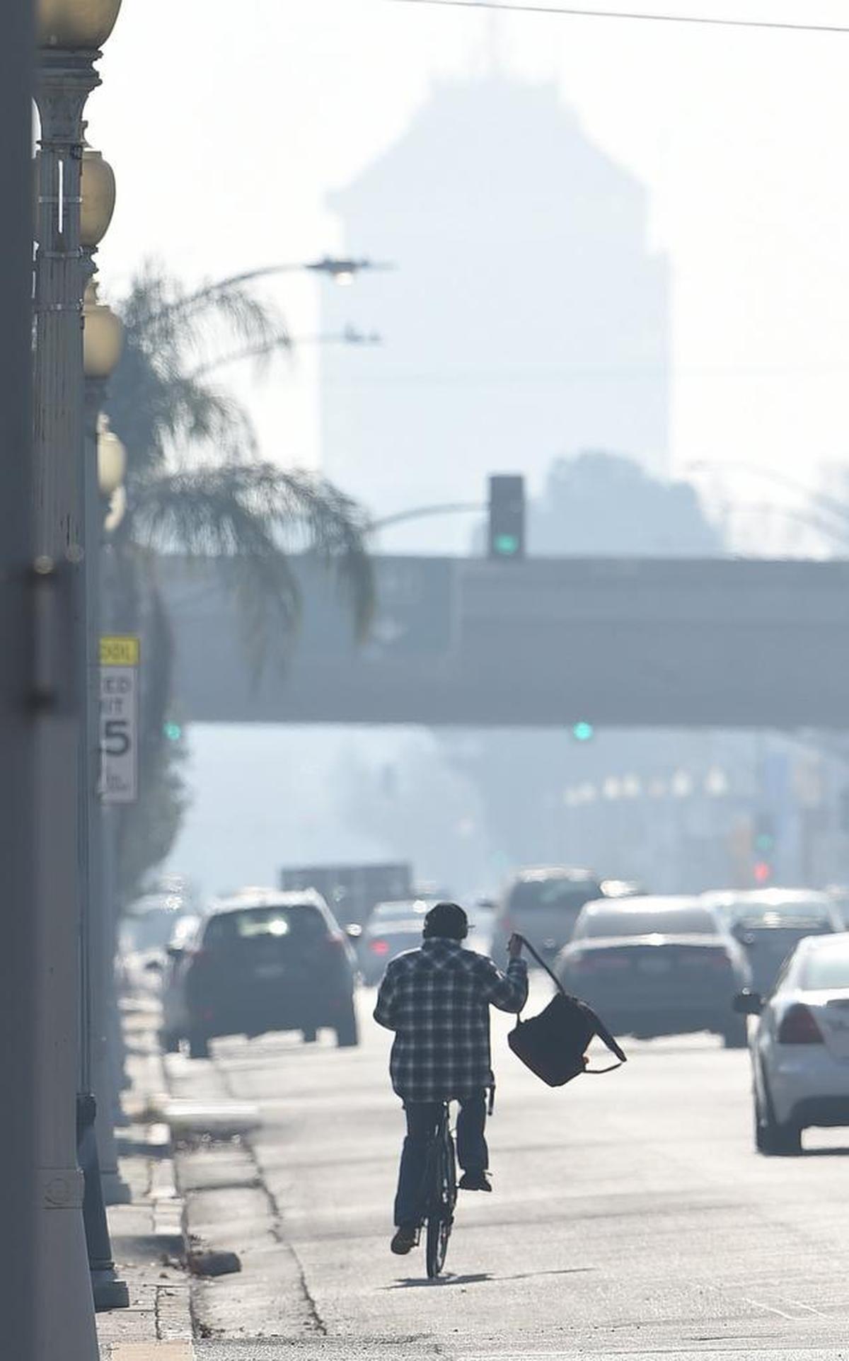 The Security Bank Building looms faintly in the background, looking down Blackstone Avenue, during a bad air day, looking east from Highway 180, Thursday afternoon, Dec. 28, 2017.