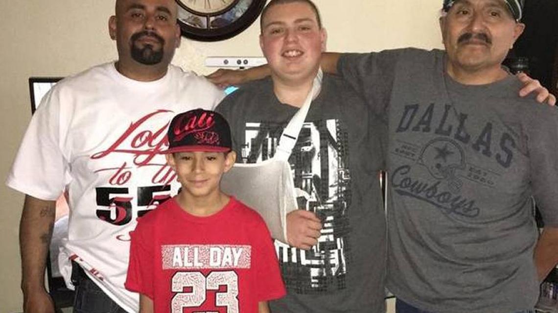 Dominic Elliott, in sling, stands with uncle Kaine Garcia, left, and grandfather, Abel Garcia, right, and cousin Isiah Garcia.
