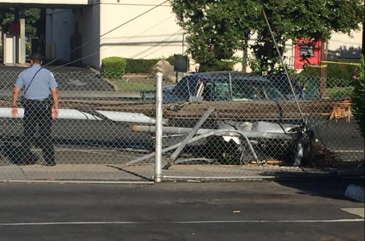 A damaged vehicle can be seen where three people, including a police officer, were injured in central Fresno on Wednesday, July 26, 2017.