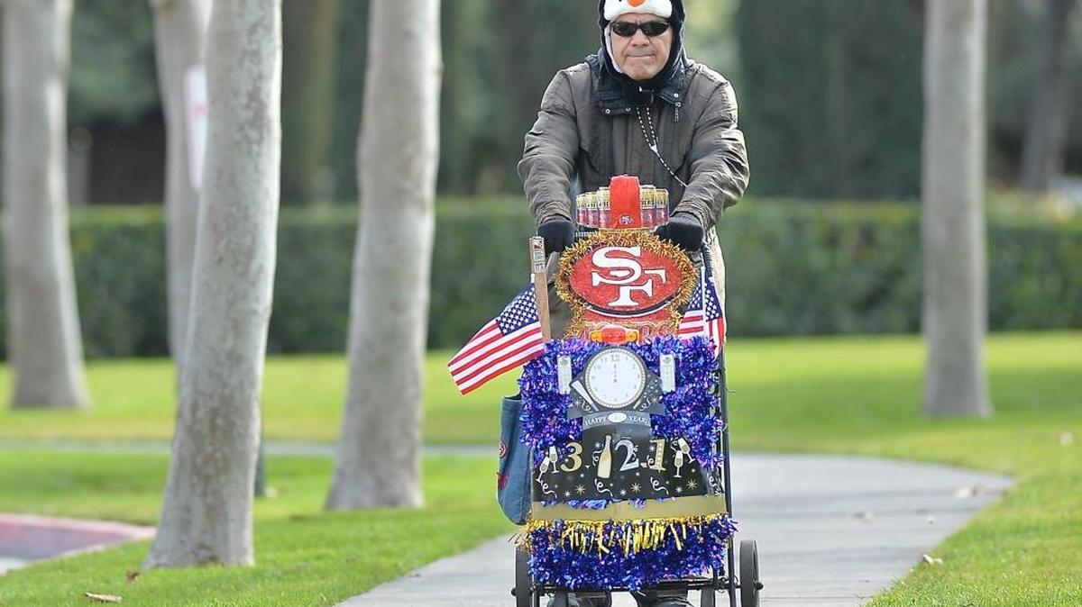 49ers fan Esteban Martinez, 69, of Fresno, keeps warm with his penguin hat as he takes a walk to the pharmacy with his shopping cart decorated for the new year on Saturday morning in downtown Fresno.