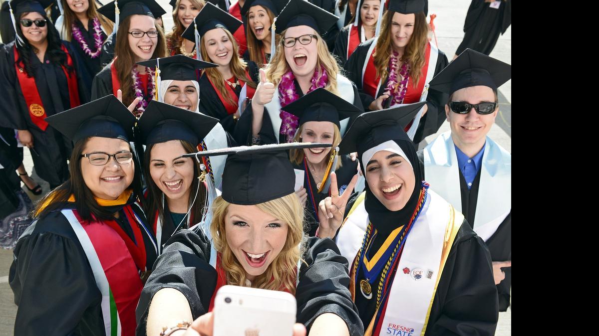 
Fresno State graduate Ludie Olenchalk, center, of Sonora takes a group selfie photo with Kreman School of Education and Human Development classmates before entering the Save Mart Center for the university's 104th commencement Saturday, May 16. Entrance requirements to get into the university will be changing in the 2016-17 year.
