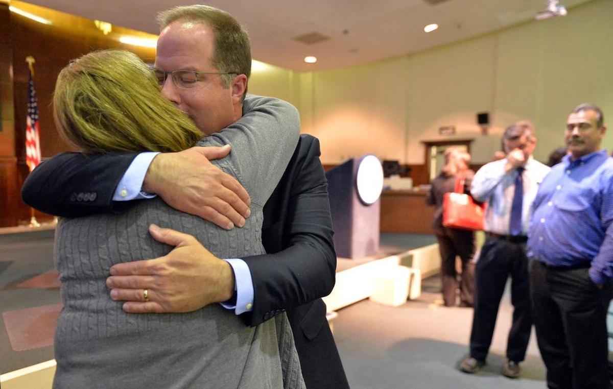 Former Fresno Unified School District Superintendent Michael Hanson gets a hug from a well-wisher after he announced his resignation in December 2016.