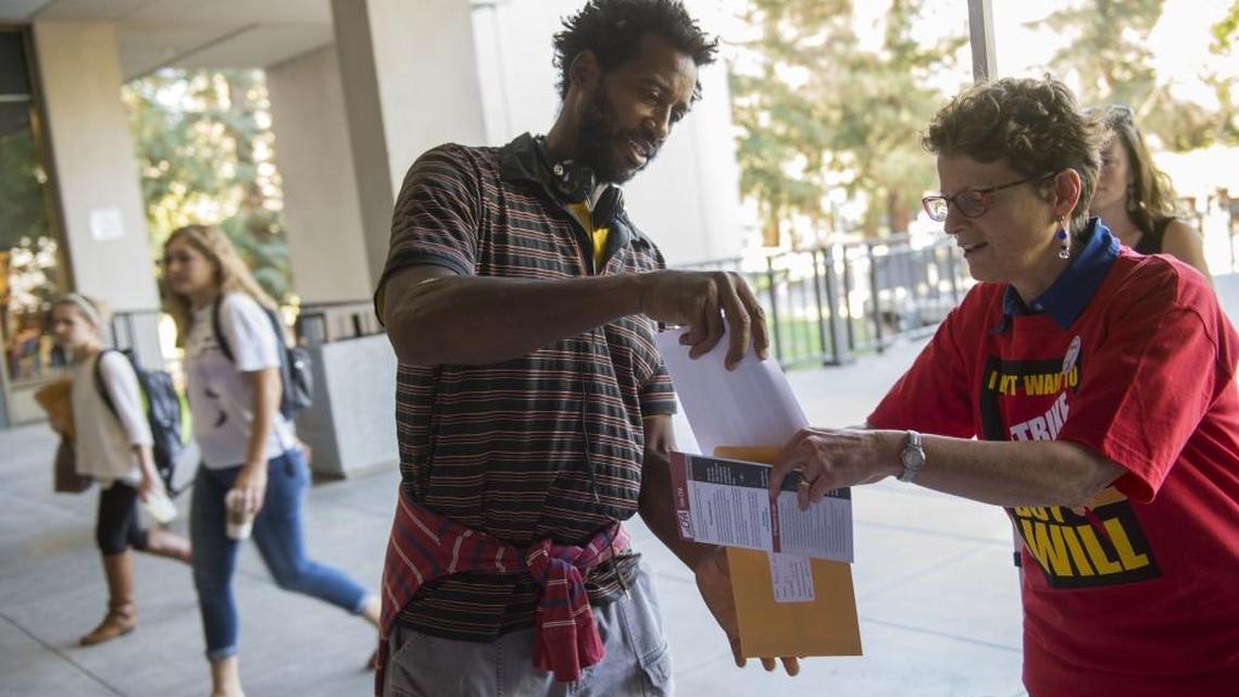 Robert Crawford a math learning skills teacher at Sac State puts in his vote, Tuesday, October 20, 2015, with help from Sac State lecturer Lois Boulgarides, right, in the breezeway of the library at Sac State as faculty there held in-person voting for strike authorization. The California Faculty Association union on Monday said the faculty will strike for five days in April if a deal is not reached.