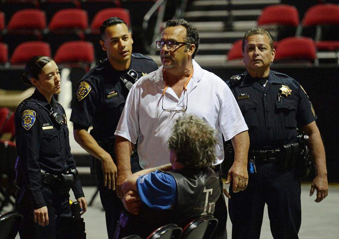 A man is followed by Fresno State police officers after giving a profanity-laced tirade toward Fresno State President Joseph Castro about how the university handled the recent tweets by professor Randa Jarrar during a public forum at the Save Mart Center on Thursday, May 3, 2018.