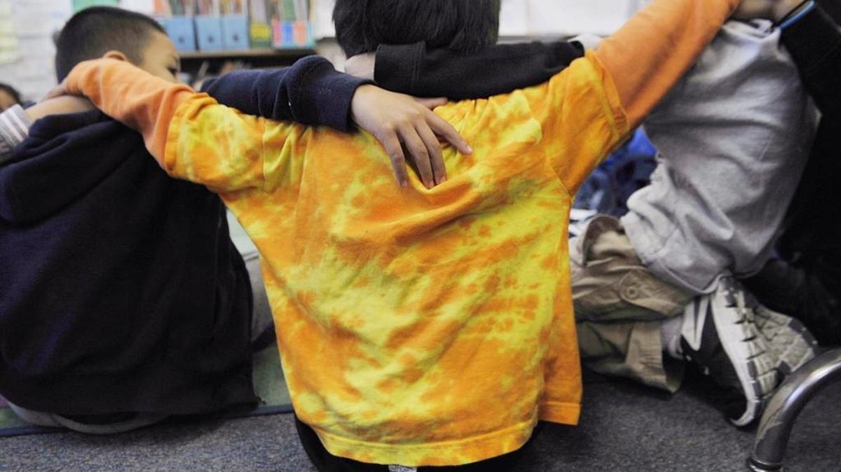 First-graders, sitting in a circle, hug as a group during a classroom session at Alice Birney Elementary School in Fresno. Students meet together as an entire class as well as in smaller more private groups as part of the restorative justice program used in Fresno Unified School District.
