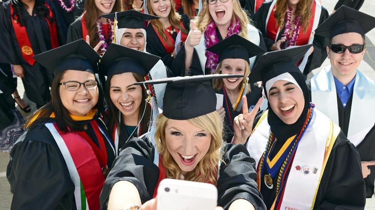Fresno State graduate Ludie Olenchalk, center, of Sonora takes a group selfie photo with Kreman School of Education and Human Development classmates before entering the Save Mart Center for the university's 104th commencement Saturday, May 16, 2015. Fresno State will hold graduation events for the class of 2016 this week.