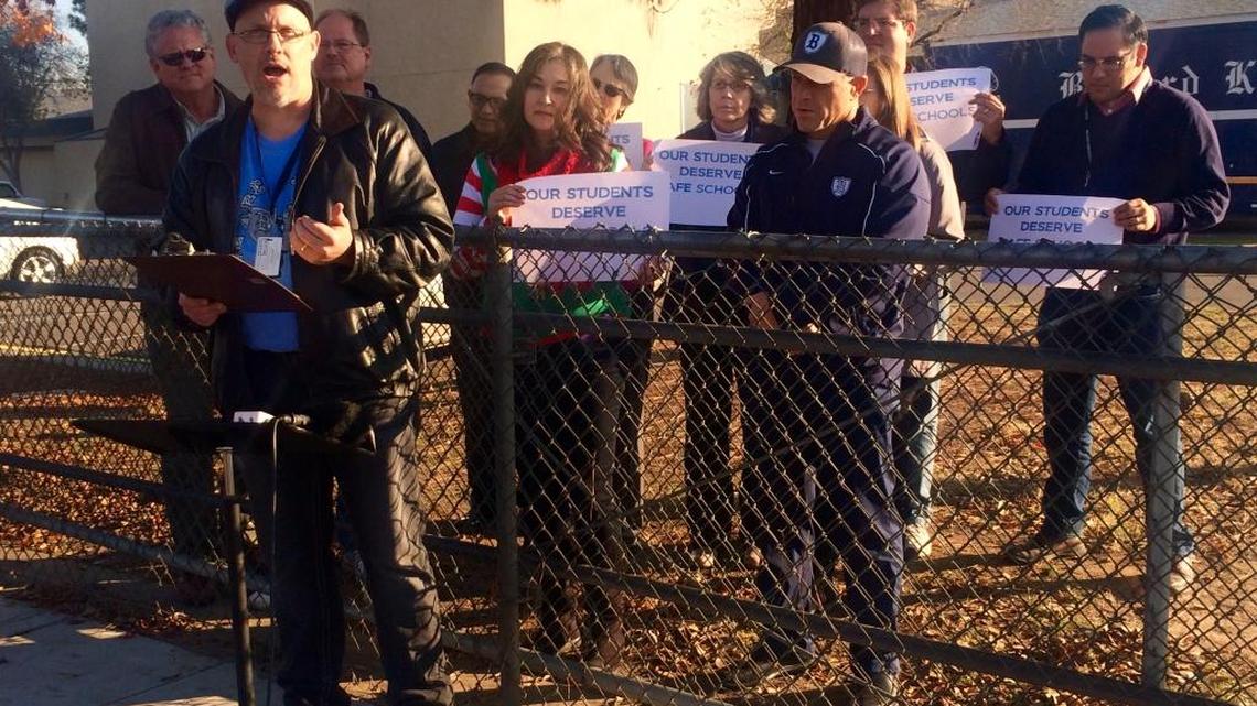 Bullard High School science teacher Scott Hatfield announces a petition calling for safety and discipline improvements on Wednesday. Teachers in the background hold signs saying, “Students deserve safe schools.”