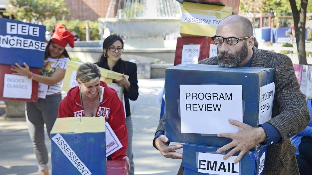During an October 2015 strike authorization rally, Fresno State professor John Beynon, right, joins other California Faculty Association members as they act in their “Race to the Bottom” skit to illustrate what they call an inadequate 2-percent raise offer.
