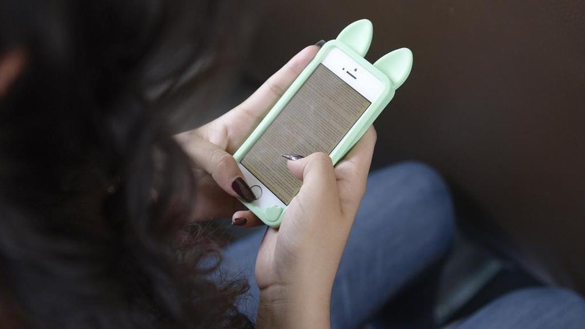 A student reads on her phone at the Fresno Unified School District.