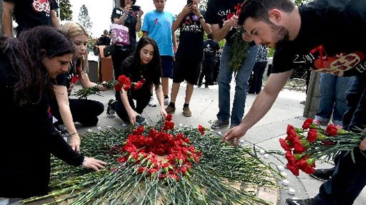People lay red carnations in remembrance at Fresno State’s Armenian Genocide Monument in April 2016.