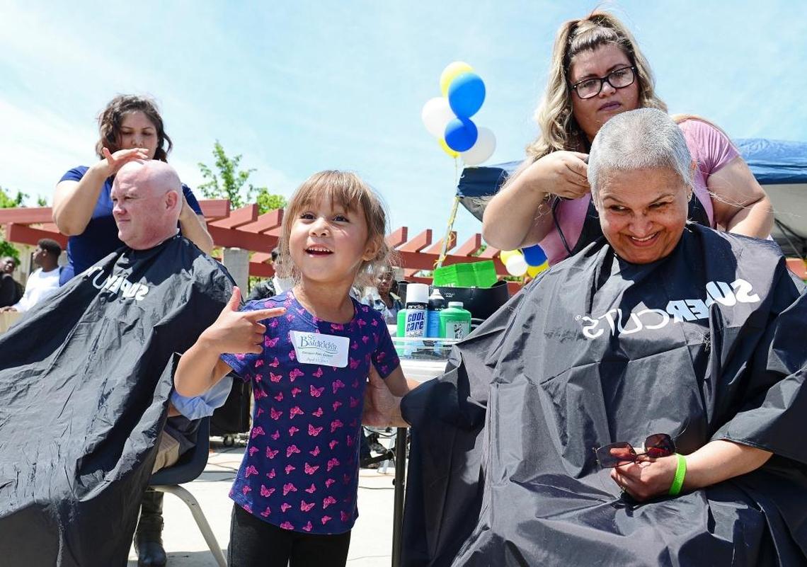 Jordynn Culver, 3, reacts as her grandmother, Sunnyside High School staff member Yolanda Lujan, right, and Fresno Unified interim superintendent Bob Nelson have their heads shaved in support of a fundraiser for the St. Baldrick’s Foundation to raise money for kids with cancer, at Sunnyside High School on Thursday, April 27, 2017.