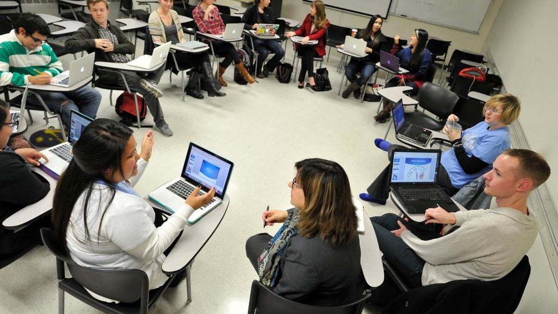 Fresno State instructor Dr. Kimberly Coy, foreground right, talks with student Roseleen Empleo, foreground left, as class gets underway to train future teachers. Budget cuts proposed by President Donald Trump could affect financial programs that help Fresno State students attend college.