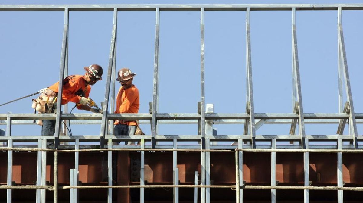 Harris Construction workers put beams into place on the roof of one of two classroom buildings being built at Fresno High School Thursday, October 25, 2012.