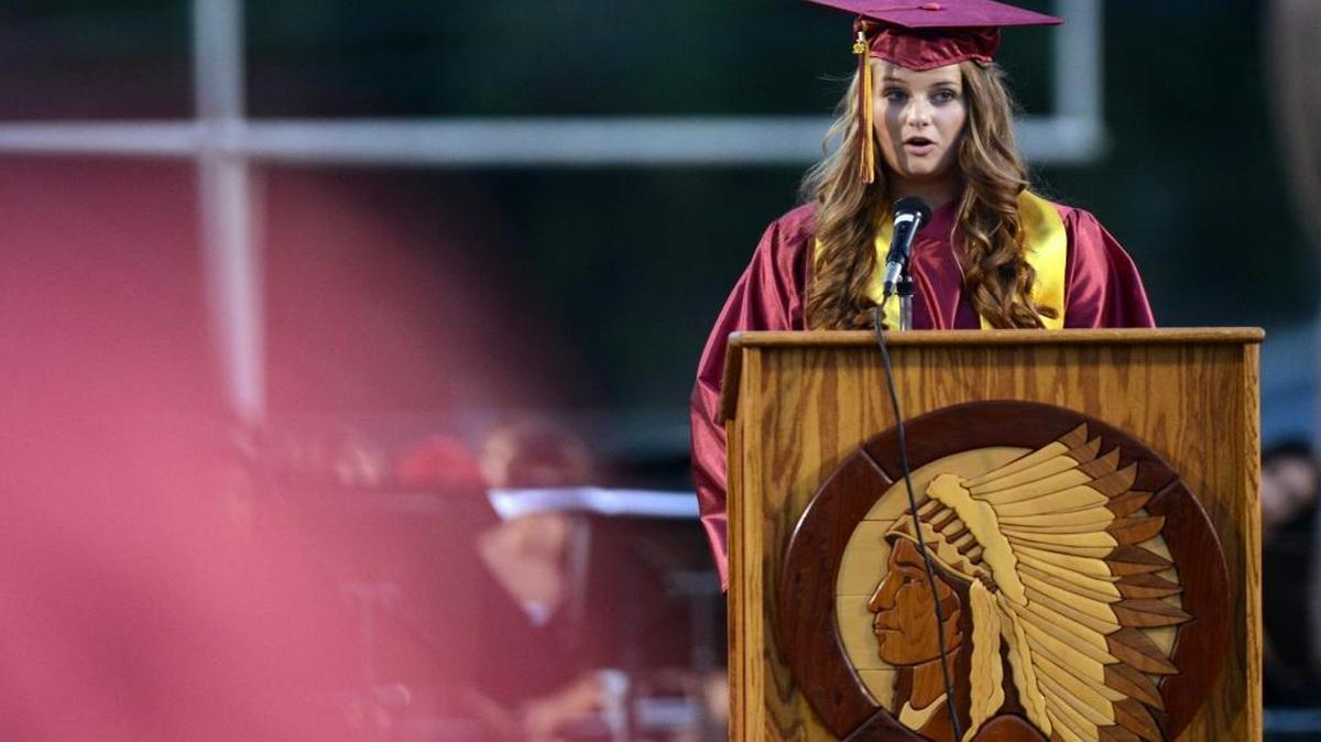Tulare Union High School valedictorian Allison Ross gives her speech during the school’s 2013 graduation. The Redskins emblem adorns the podium. Tulare Union must find a new mascot to conform with a new state law.