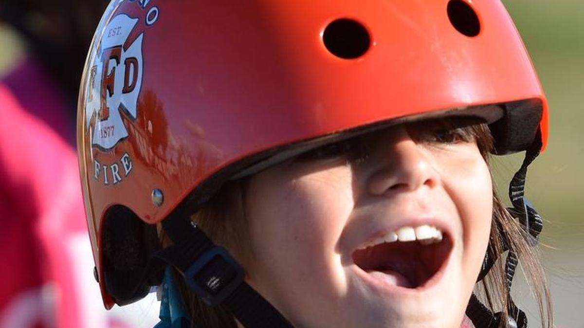 Third grader Emma Barr, 9, tries on her new helmet on Monday, December 14, 2015 at Teague Elementary School in Fresno, California. Ninety-three Teague third graders received a new bike and helmet on Monday, courtesy of Celebration Church and the Fresno Fire Chief’s Foundation.