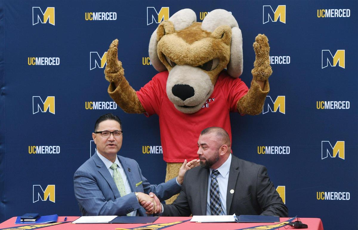 UC Merced Chancellor Juan Sánchez Muñoz, left, shakes Fresno City College President Robert Pimentel’s hand. Both signed an agreement creating a more robust pipeline for students between the two campuses during a ceremony Monday, Oct. 31, 2022 in Fresno.