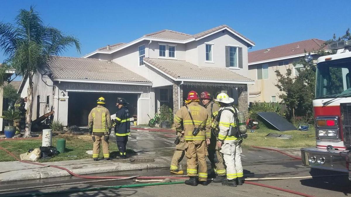 Fresno firefighters mop up after a fire breaks out in the garage of a southeast Fresno home Sunday, Oct. 1, 2017.