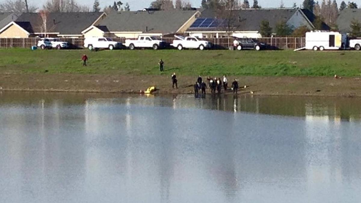 Fresno County sheriff’s dive team works to recover a body from a pond in northwest Fresno on Tuesday, Jan. 12, 2015.