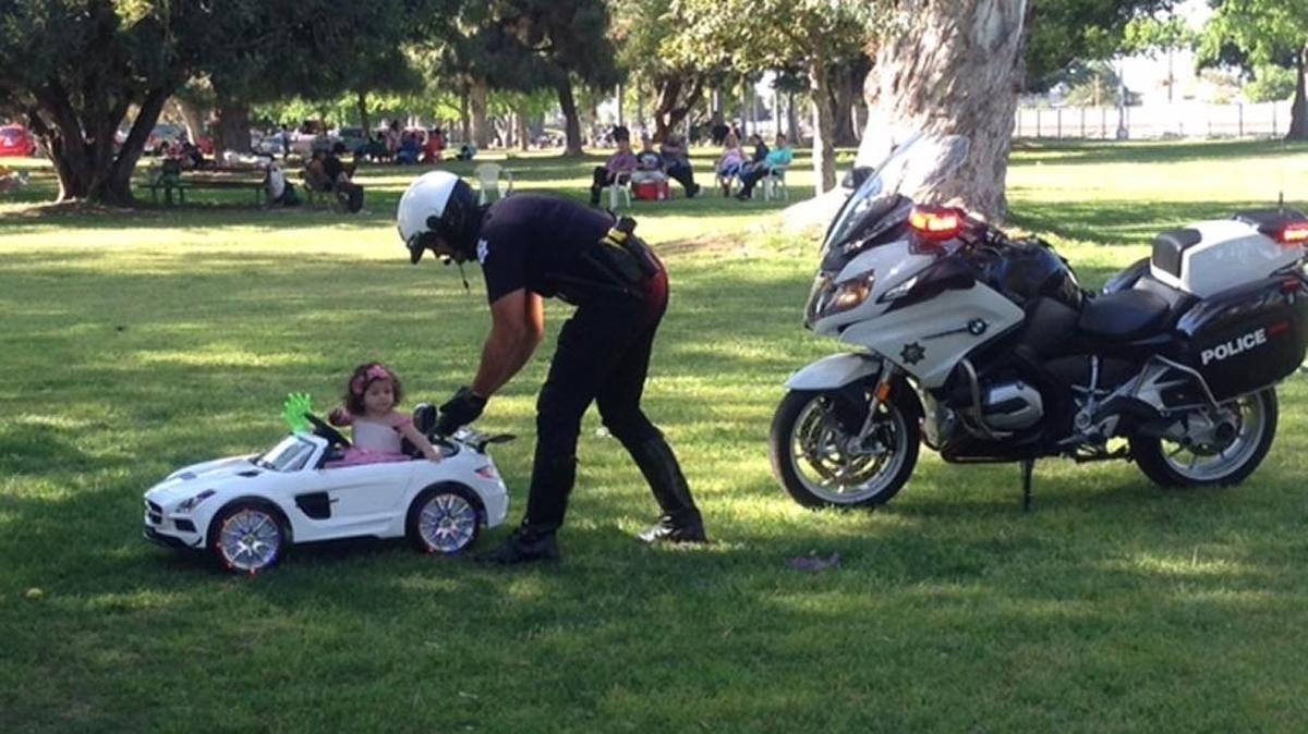 Fresno Police Officer Erik Castillo pulls 1-year-old Avery over in a pretend traffic stop Sunday, March 27, 2016, in Roeding Park.