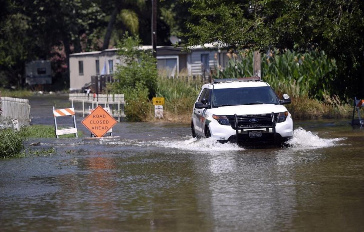 A Fresno County Sheriff’s Department SUV is driven through a flooded Riverbend Mobile Home Park along the swollen Kings River on Friday, June 23, 2017 near Centerville, Calif.