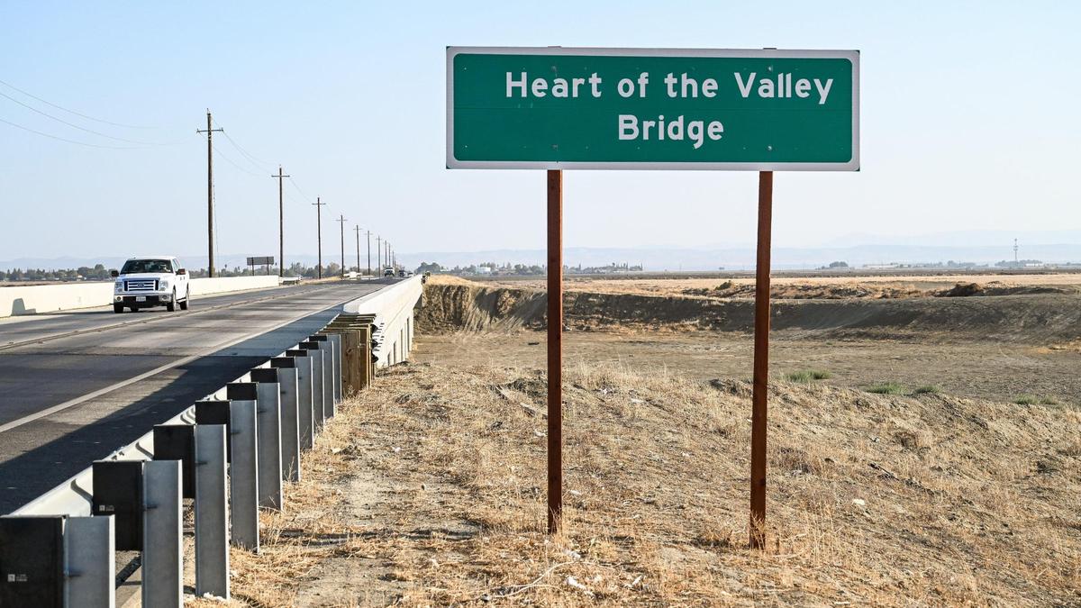 A sign denotes the Heart of the Valley Bridge on Highway 269 at Arroyo Pasajero Creek north of Huron on Thursday, Sept. 15, 2022. The recently opened bridge now spans the creek that would typically flood over the former road during rainy periods, shutting off access to Huron. Recent drought has kept the creek dry and forced many farmers to fallow their fields, drying up work for families in the process.