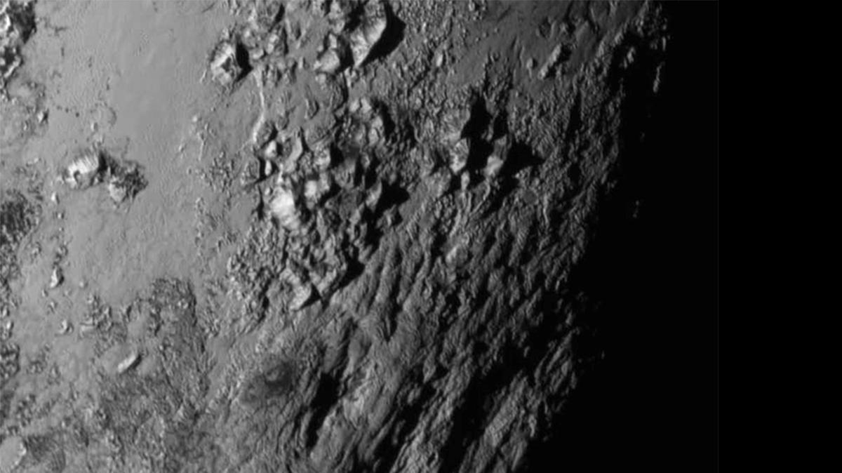 
This Tuesday, July 14, 2015 image provided by NASA on Wednesday shows a region near Pluto's equator with a range of mountains captured by the New Horizons spacecraft. 
